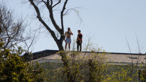 two people standing on the roof of an apartment building